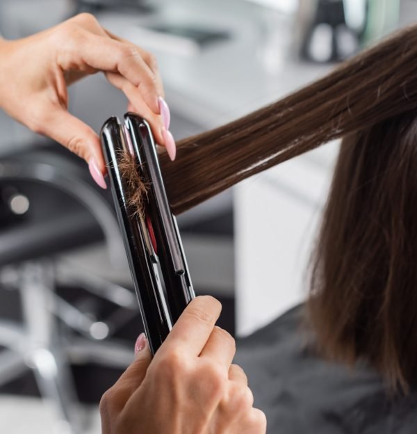 hair ironing, professional hairdresser with hair straightener styling hair of female customer, beauty worker, client satisfaction, brunette woman with short hair, beauty salon, hair fashion, cropped